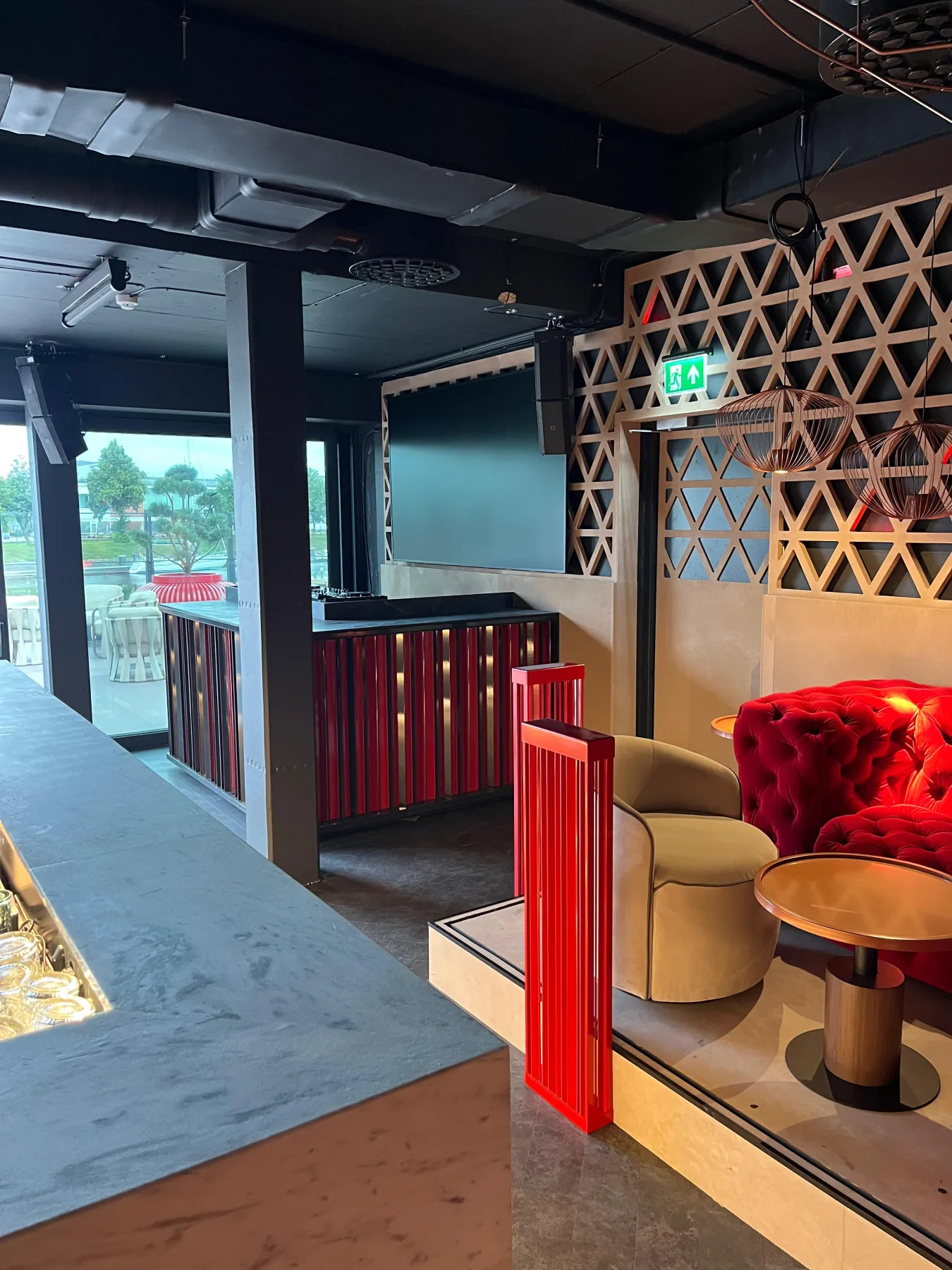 Red metal counter cladding and spatial dividers in the bar interior