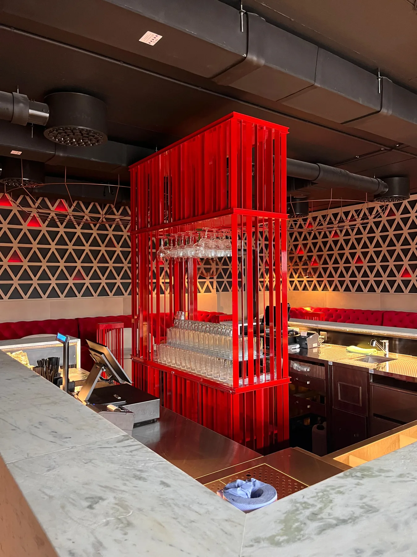 Red metal glass rack in a bar interior