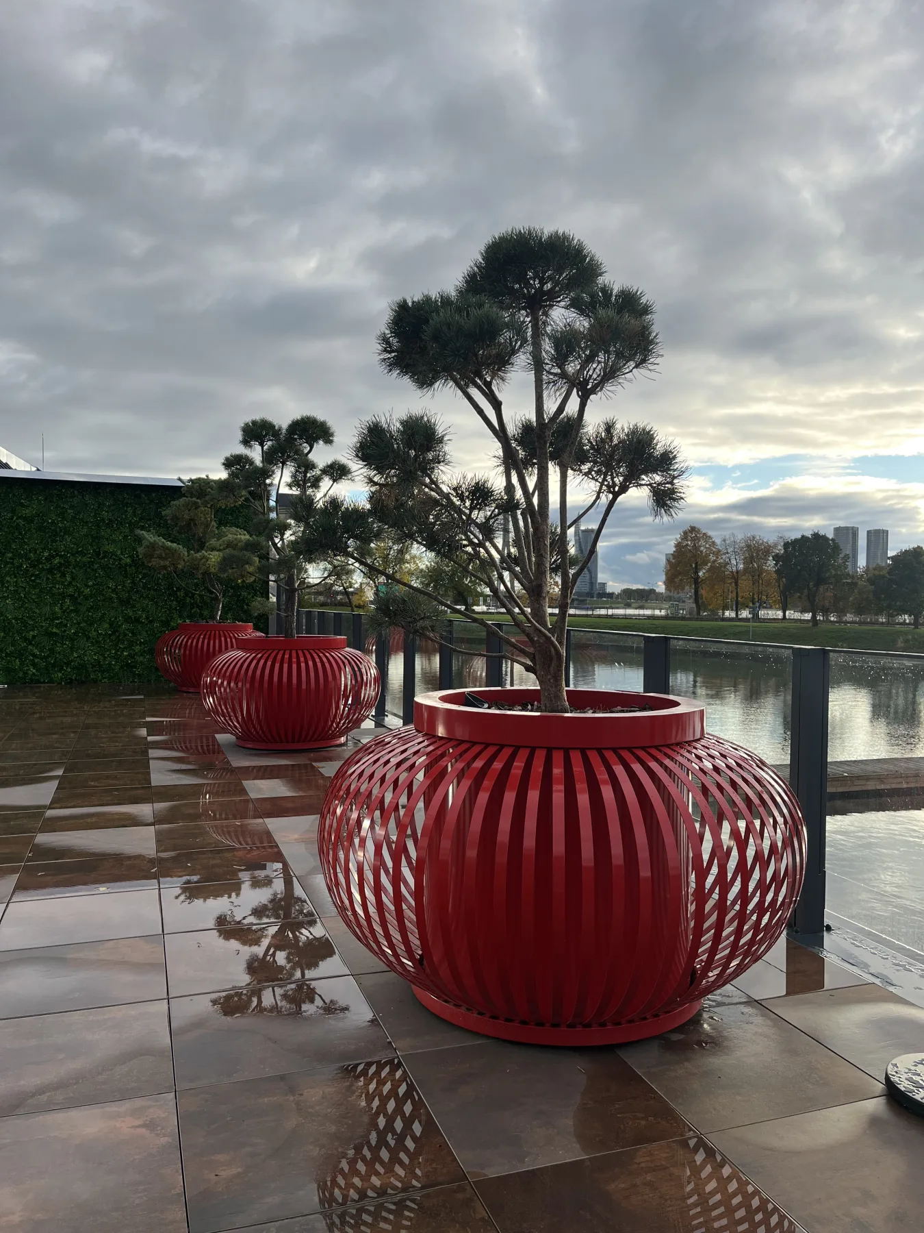Line of red ribbed planters beside the water on a waterfront terrace