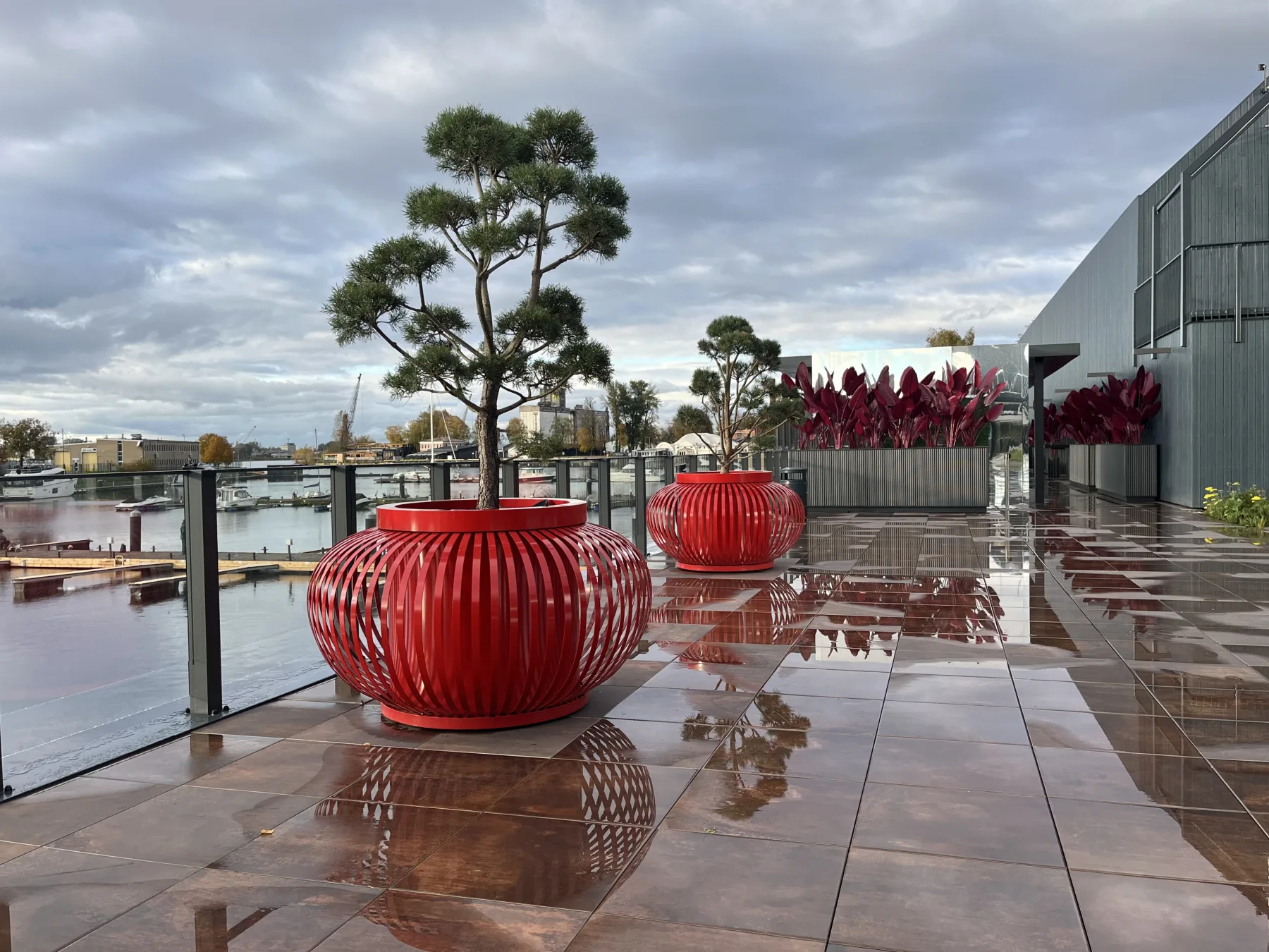Red ribbed metal planters on the waterfront terrace